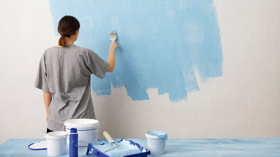 Painter applying a fresh coat of paint to an interior wall