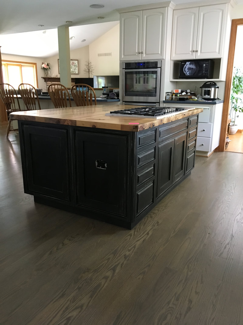 Kitchen with white perimeter cabinets and a dark painted island